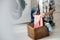 cropped view of woman in grey shirt and jeans putting clothes in basket near washer