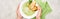 Cropped view of woman holding plate with delicious creamy green vegetable soup with croutons near green napkin