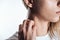 Cropped view of woman itching neck on white background.