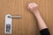 Cropped view of woman knocking at door with please do no disturb sign