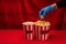 Cropped view of woman in latex glove holding popcorn on red surface with velour