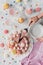 cropped view of woman putting piece of pink birthday cake with marshmallows