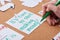 Cropped view of woman writing time to start making money inscription on card pinned on cork board.