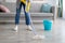 Cropped view of young housewife washing floor with mop at home, closeup of legs. Professional house cleanup concept