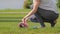 Cropped view of young woman in sportswear spreads fitness mat on green grass