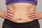 Cropped woman body with hands on waist showing belly sagging skin after diet and stretch marks