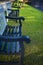 A cropping of blue wooden bench on fresh green grass in a small park with a nice sunlight casting.