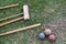 A croquet set lie on a lawn of grass with three balls