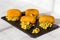 Croquettes fried in oil, with guacamole sauce on black stone plate at kitchen. Side view on white wooden background.