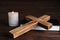 Cross, Bible and burning candle on background, closeup. Christian religion