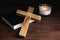 Cross, Bible and burning candle on wooden background, closeup. Christian religion