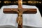 Cross with body of Jesus in front of open blurry Bibe and gold hearts