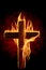 Cross burning or lighting concept theme with a wooden crucifix engulfed in fiery flames isolated on black background. It was used