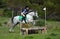 Cross country rider and pony jumping