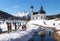 Cross-country skiers on sunny track along a river and a pitoresque church, Seefeld, Austria