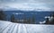 Cross country skiing. Empty touring ski trail. Snowy mountains in the background