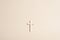 Cross or crucifix on light beige background. Clean simplistic design