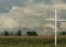 Cross in Field with Storm Clouds Above