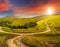 Cross road on hillside meadow in mountain at sunrise at sunset