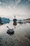 Cross on rock in lake Mond surrounded mountains