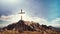 cross on rocky mountain with clear sky