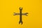 Cross of rusty keys on a yellow background