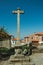 Cross shape pillory made of stone in courtyard and old houses