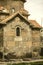 Cross-shaped Karmravor Church with overlooking aspida, covered with red tiles, arched window in the city of Ashtarak