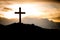 The cross standing on meadow sunset and flare background.Cross on a hill as the morning sun comes up for the day.