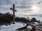 Cross standing on a snowy mountaintop