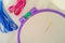 Cross stitch fabric in plastic embroidery hoop with needle, red and blue threads