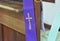 A cross symbol on a purple cloth for the priest is placed on a wooden platform for the confession of sins in Christianity