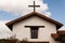 Cross on top of spanish mission style church in country