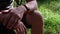 Crossed male hands closeup with green grass background