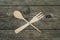 Crossed wooden fork and spoon on rustic background