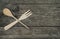 Crossed wooden fork and spoon on rustic background