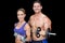 Crossfit couple posing with dumbbells smiling at camera