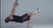CrossFit fitness man training TRX exercises at studio isolated on bluish background, man doing push-ups with one leg up
