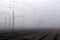 Crossing railways disappearing in the mist in autumn morning