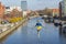 Crossing the river - a balancing sculpture of a tightrope walker over the Brda River. Man in a t-shirt - flag of Ukraine