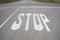 Crossroads with stop signal painted on asphalt