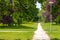 Crossroads of trails in the park. Stormy greens, lots of bushes and green trees. lanterns standing along the path in the