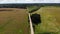 Crossroads two gravel roads. Bushes in summer field. Aerial view countryside