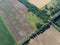 Crossroads of two roads among farm fields, aerial view. Agrarian landscape, bird`s-eye view