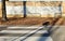 Crosswalk and grunge brick wall with erased graffiti. A sidewalk full of fallen leaves with metallic divider