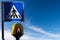 Crosswalk Sign and Pedestrian Traffic Light on Blue sky with Clouds