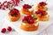 Crostini appetizers with cranberries, brie and caramelized onions, close up on a white platter