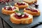 Crostini appetizers with cranberry sauce, cheese and rosemary on slate