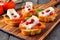 Crostini appetizers with persimmons, pomegranates and brie, close up on wood platter