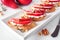 Crostini appetizers with red pears, whipped feta cheese and walnuts. Close up table scene.